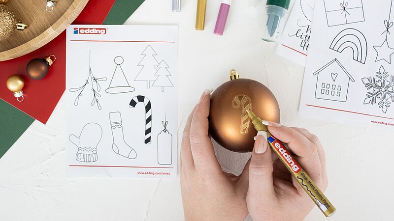 Weihnachtskugel wird mit Glanzlackmarker bemalt