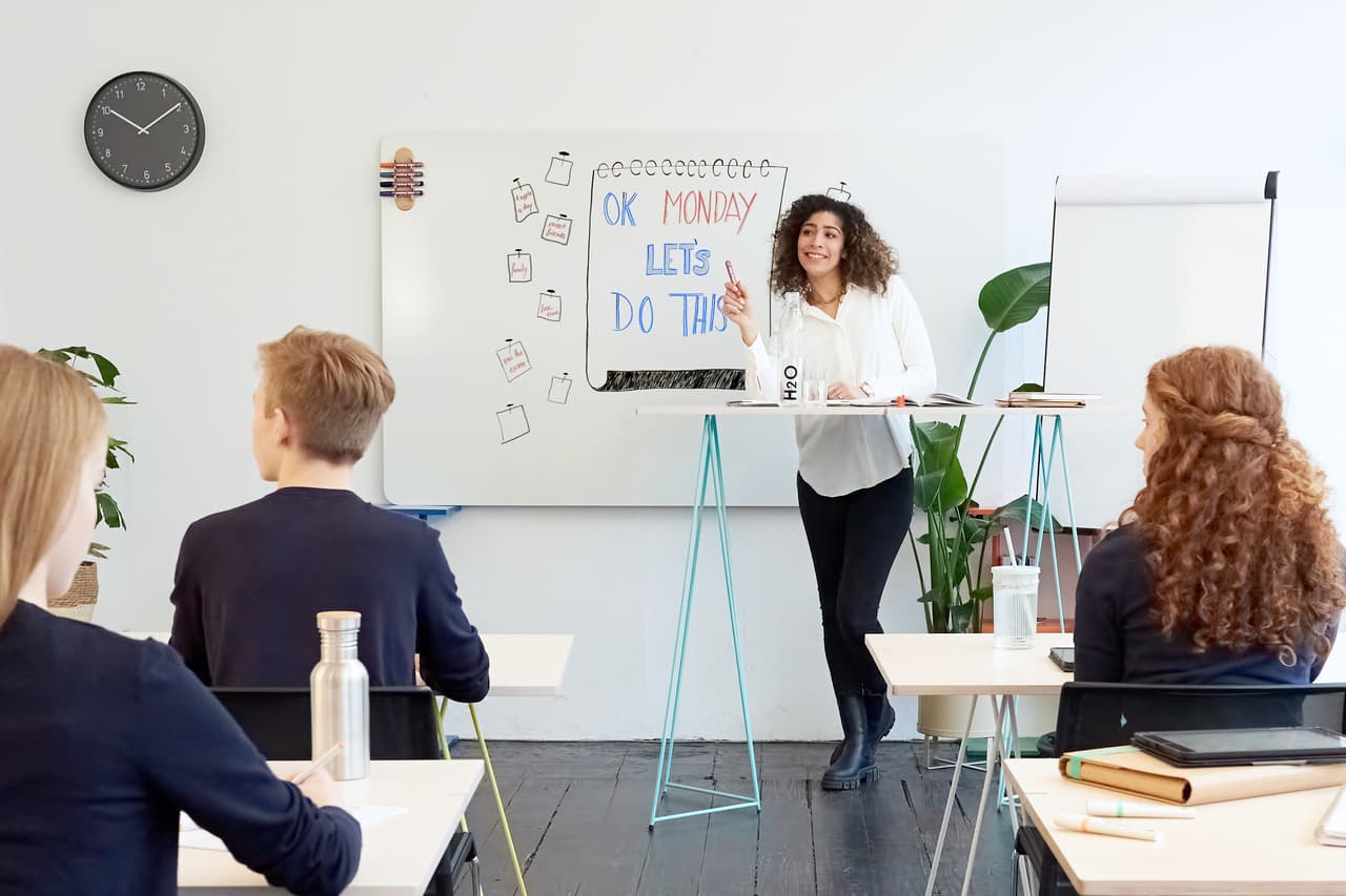 Ein motivierter Dozent startet die Arbeitswoche mit einer begeisterten Präsentation vor einem engagierten Publikum in einem hellen, modernen Büroraum unter Verwendung eines edding 360 Whiteboardmarkers 8er-Set, Rundspitze mittelbreit mit nachfüllbarer Tinte (nachfüllbar).