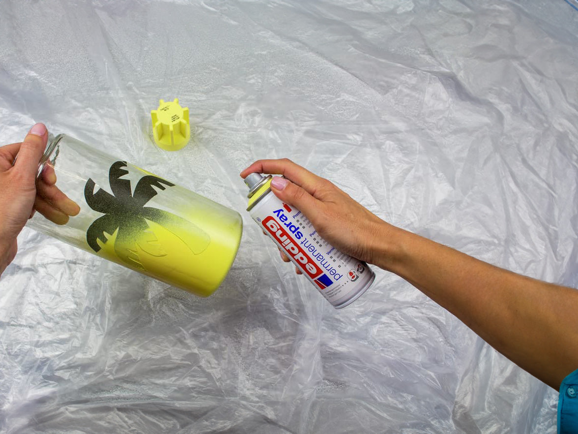 Glas wird mit gelbem Permanentspray besprüht