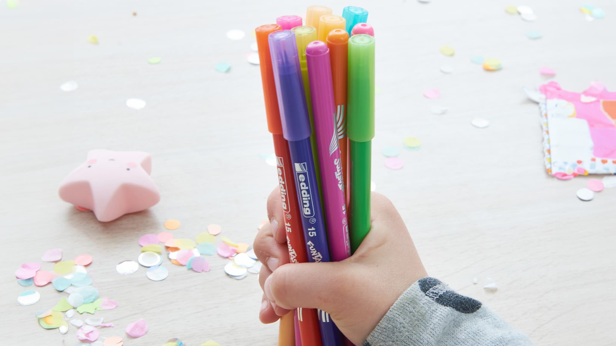Kinderhand hält Filzstifte
