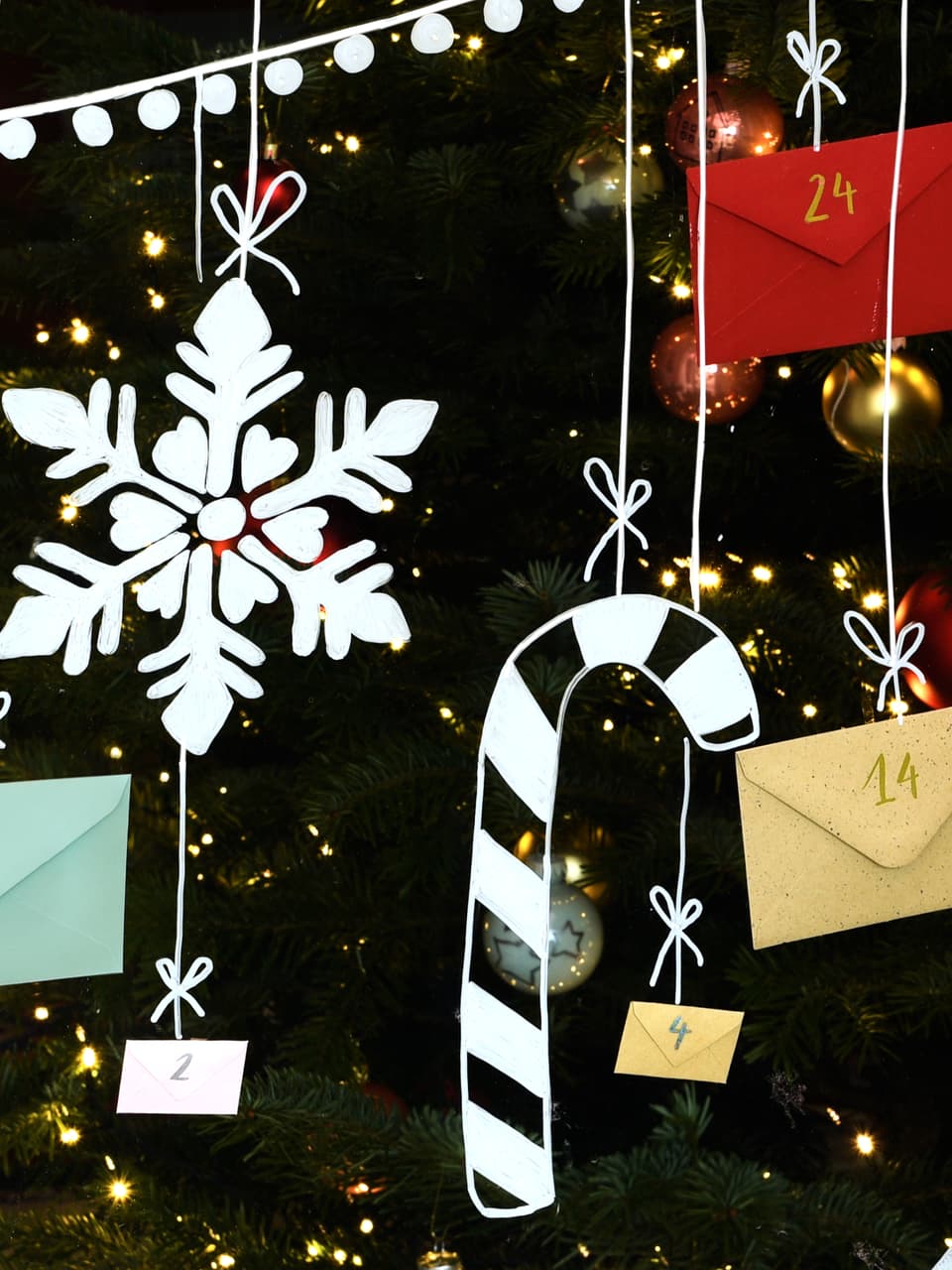 Ein festlicher Weihnachtsbaum mit funkelnden Lichtern, eine große dekorative Schneeflocke und ein Adventskalender mit Umschlägen, die den Countdown bis zum Weihnachtstag darstellen, alles hervorgehoben unter edding 4085 Kreidemarker UV-Licht.