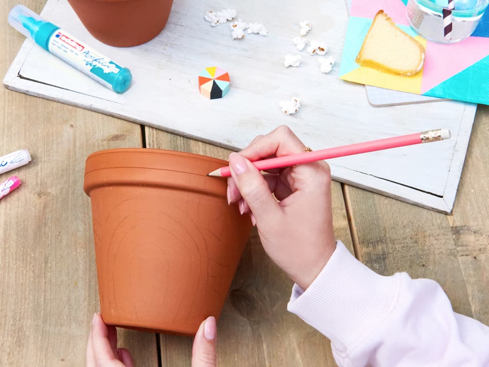 Muster wird mit Bleistift auf Tontopf vorgemalt