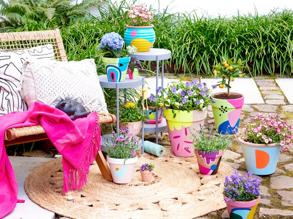 Bunte Tontöpfe bemalt mit Acrylmarkern im Garten