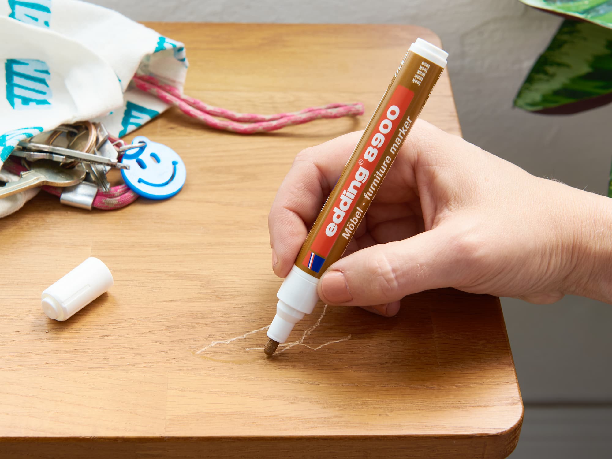 Möbelmarker übermalt Kratzer auf Holzbank