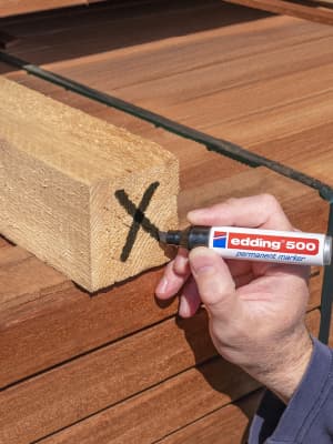 edding 500 ein Kreuz wird auf ein Stück Holz gezeichnet