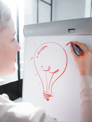 Frau bemalt ein Flipchart mit Marker