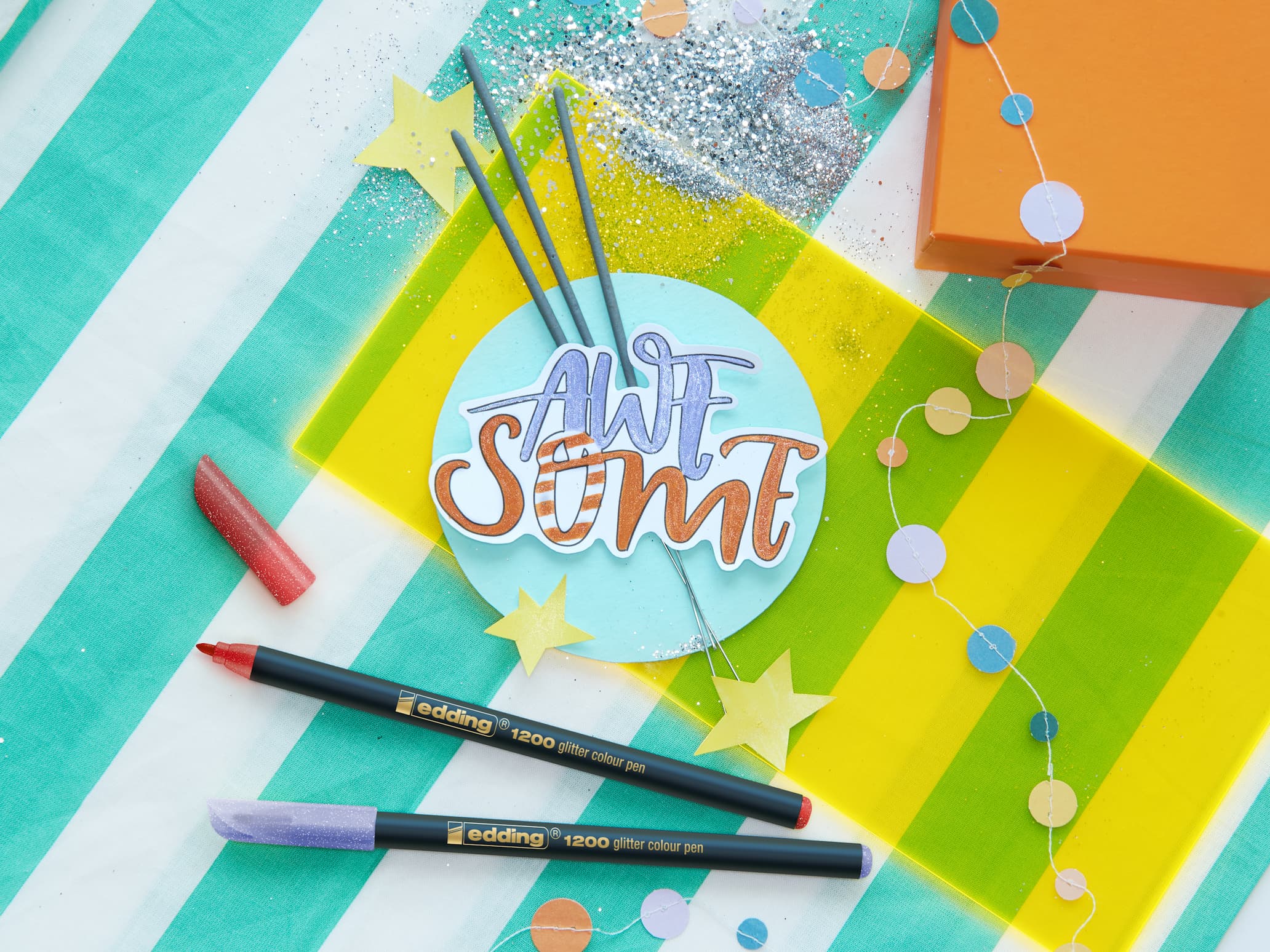 Eine Packung mit fünf edding 1200 glitzer Fasermalern mit verschiedenen Glitzerfarben für kreatives und funkelndes Schreiben oder Zeichnen.