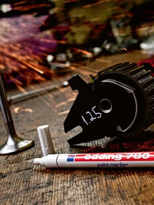 Feiner Lackmarker auf dunklem Werkstück aus Metall