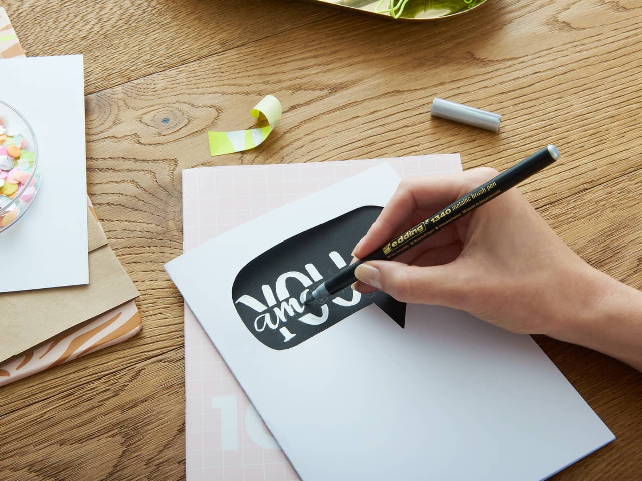 Ein Satz edding Happy Lettering Set Pinselstifte und ein Lettering-Übungsbuch, perfekt für alle, die Kalligraphie und Handlettering lieben.