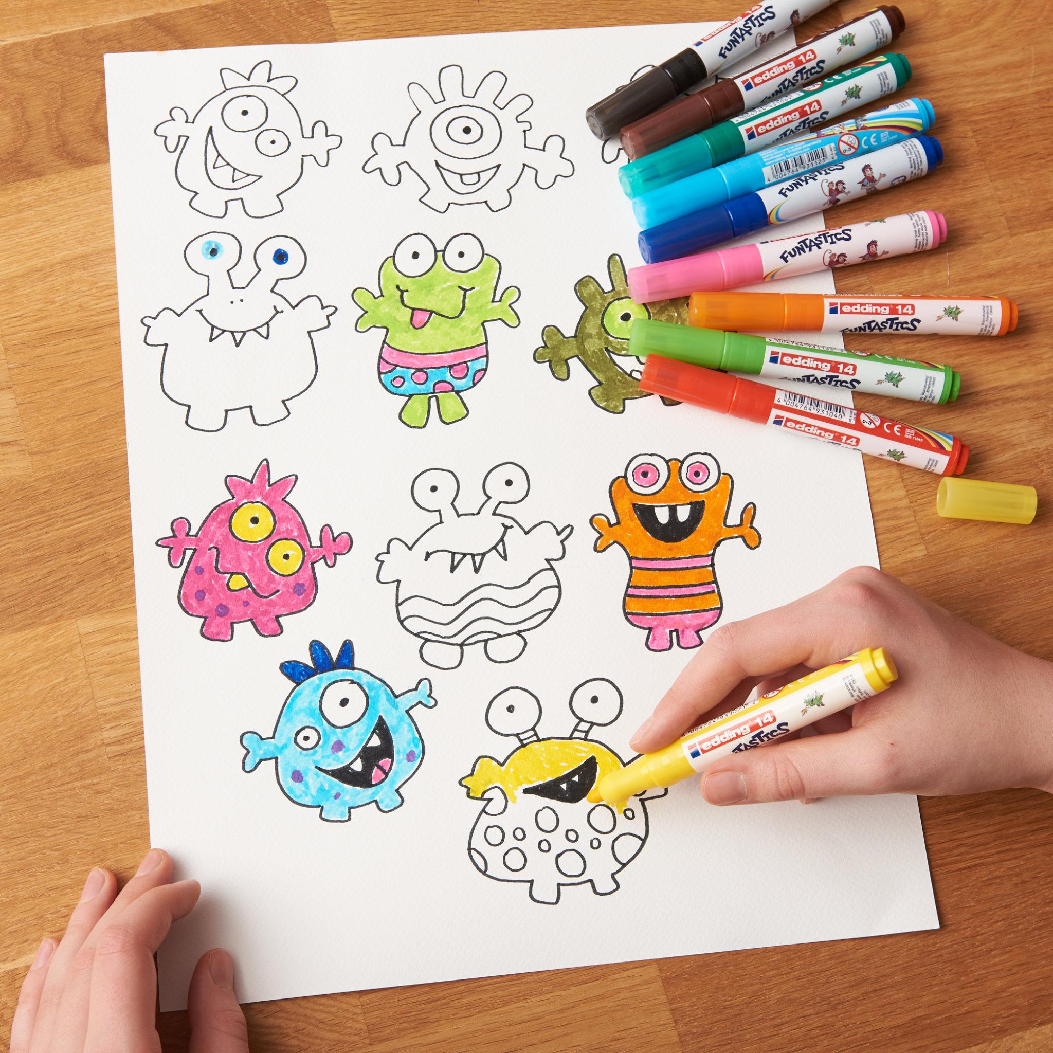 Die Hände eines Kindes malen in skurrilen Monsterillustrationen mit lebendigen edding 14 FUNTASTICS Kinderfasermaler-Markern auf einem Holztisch.