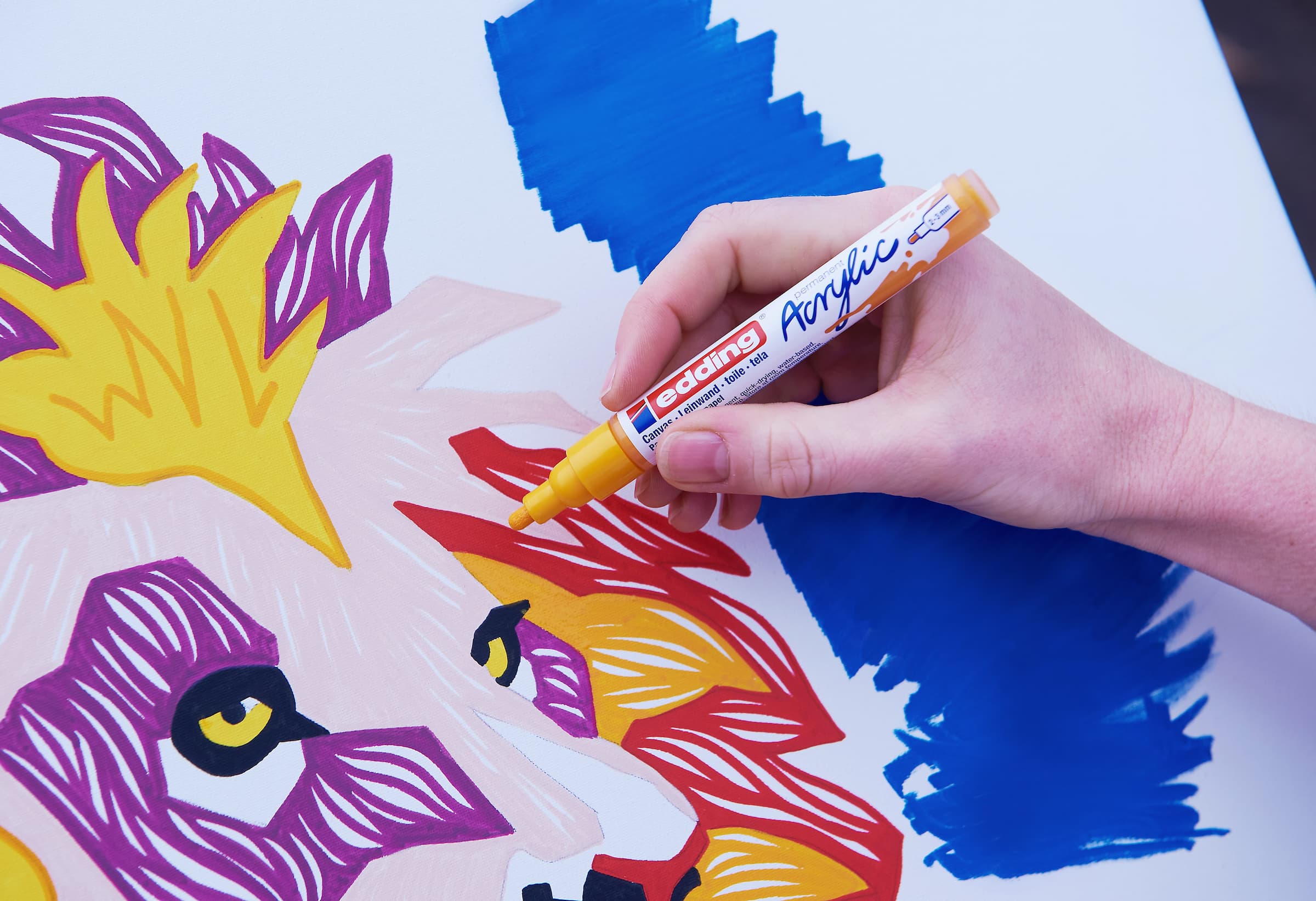 Hinzufügen lebendiger Details zu einem farbenfrohen Löwen-Kunstwerk auf Leinwand mit einem edding 5100 Acrylmarker-Medium.