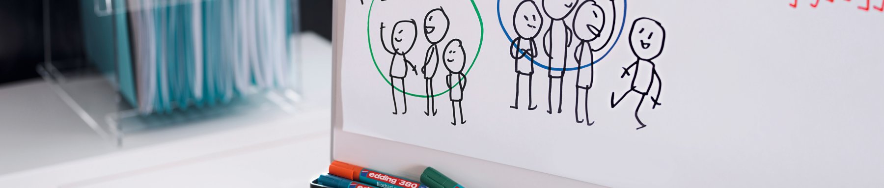 Eine Panoramaansicht eines Whiteboards mit einer handgezeichneten Skizze von Strichmännchen, die Teamarbeit oder Gruppendynamik hervorheben, und trocken abwischbaren Markern darunter.