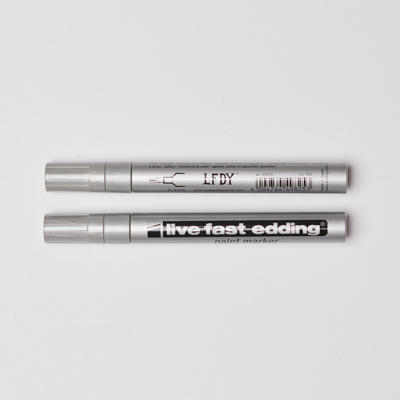 Zwei edding LFDY Lackmarker - Live Fast edding Silberlackmarker liegen horizontal auf weißem Untergrund. Auf einem Marker steht „LFDY x edding“, auf dem anderen „live fast edding“.