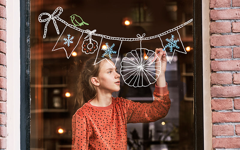 edding Kind bemalt Fenster mit Kreidestift