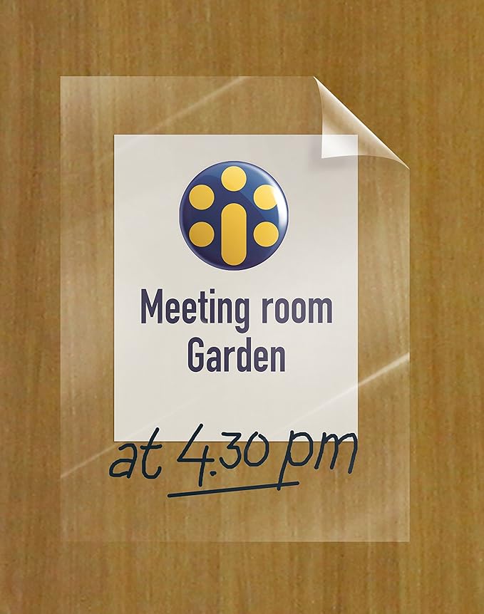 Auf einem auf eine Holzoberfläche geklebten Schild steht „Meeting Room Garden“ mit einem Logo darüber und darunter handschriftlich „um 16:30 Uhr“, möglicherweise mit einem Legamaster Boardmarker. Die Notiz ist auf Legamaster Magic-Chart Clearboard Folie geschrieben und die Ecke des Papiers ist leicht gewellt.