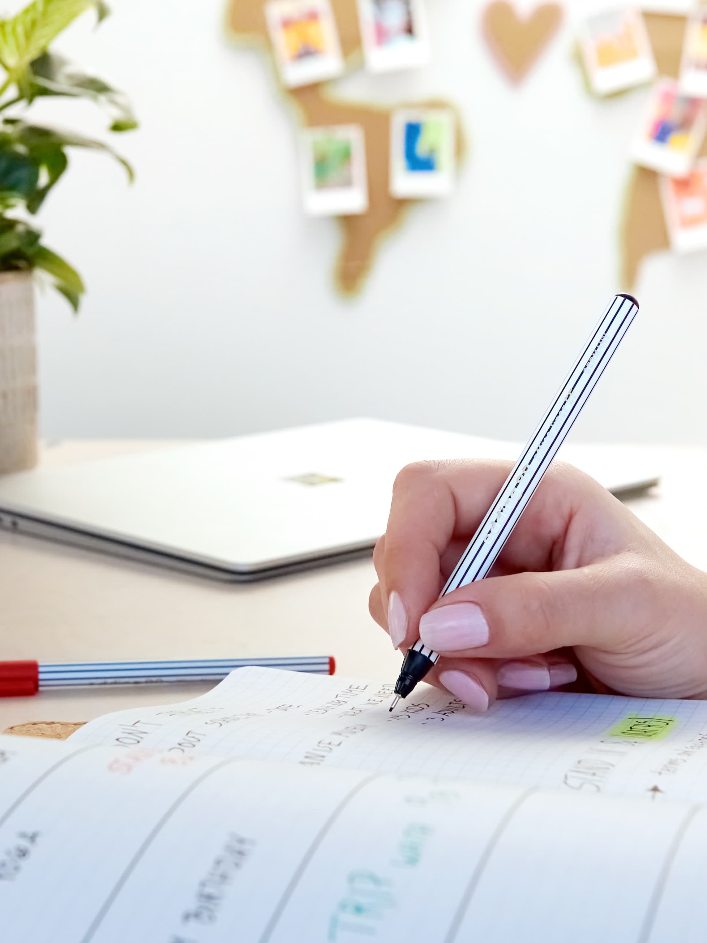 Jemand schreibt mit einem Fineliner in ein Notizbuch